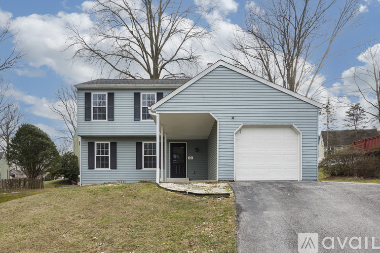 A blue house with a white garage door is for sale.