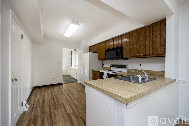 A kitchen with wooden cabinets and a white sink.