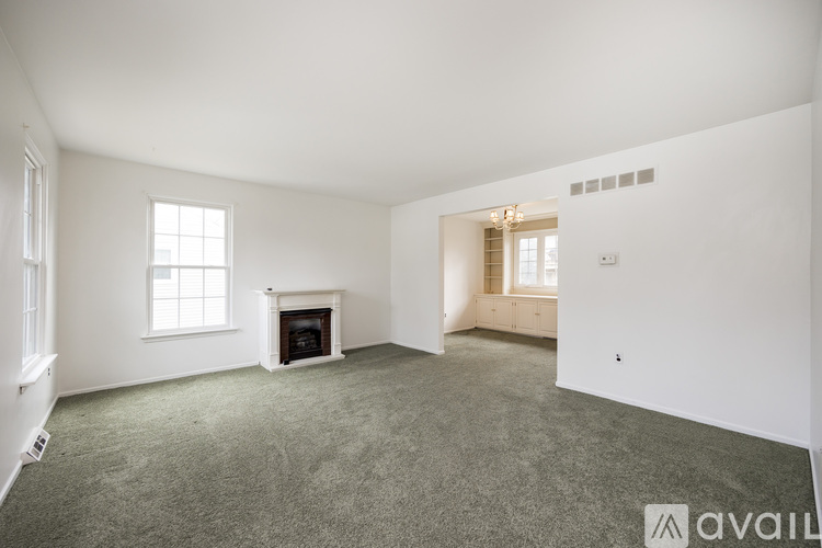 A spacious room with a fireplace and a window.