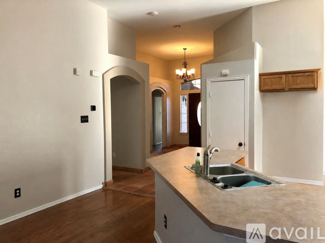 A kitchen with a sink and a chandelier.