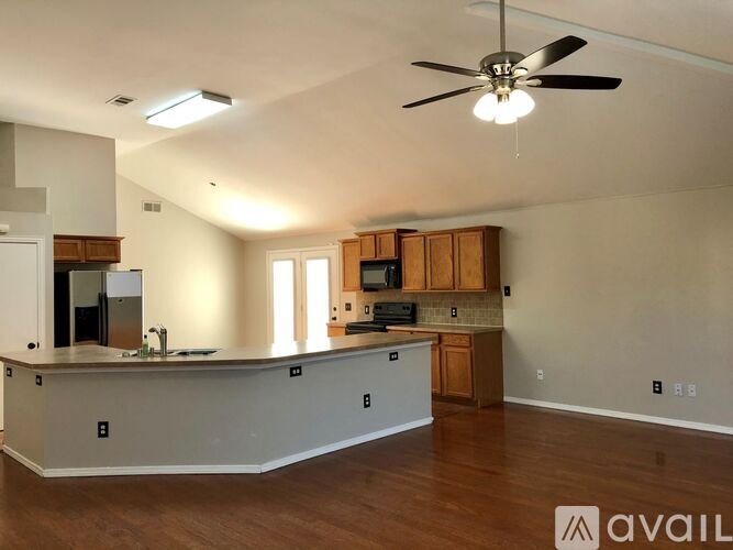 A spacious kitchen with wooden cabinets and a white countertop.