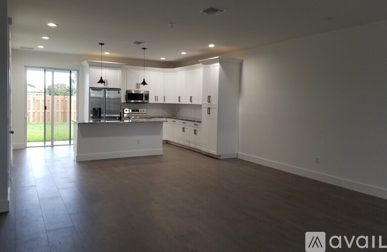 A spacious kitchen with white cabinets and a large island.