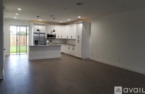 A spacious kitchen with white cabinets and a large island.