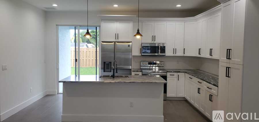 A kitchen with white cabinets and a large island.