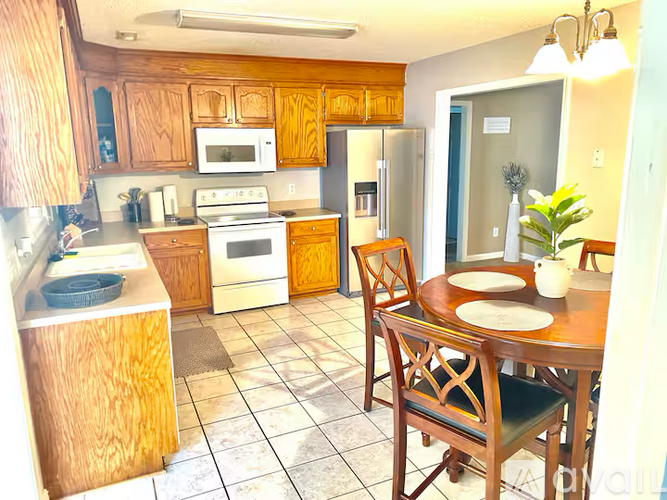 A kitchen with a table and chairs.