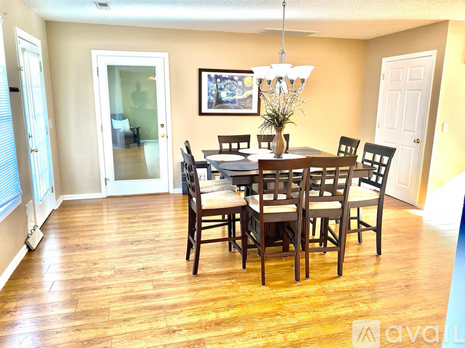 A dining room with a wooden table and chairs.