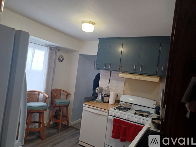 A kitchen with a white stove and blue chairs.