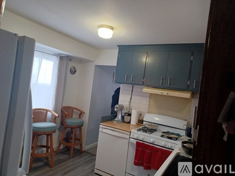 A kitchen with a white stove and blue chairs.
