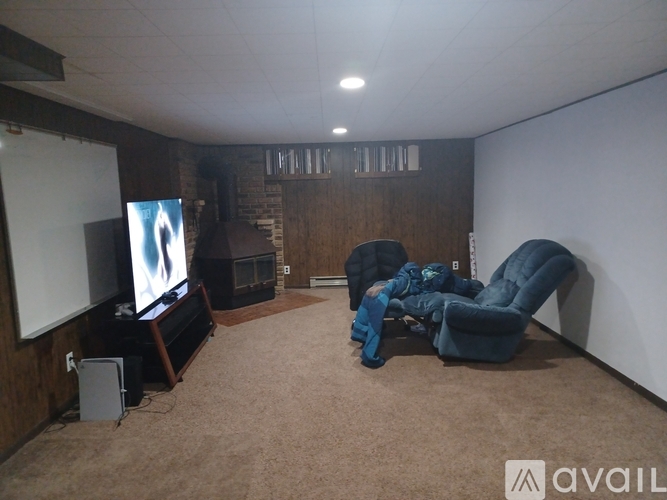 A living room with a television, a chair, and a speaker.