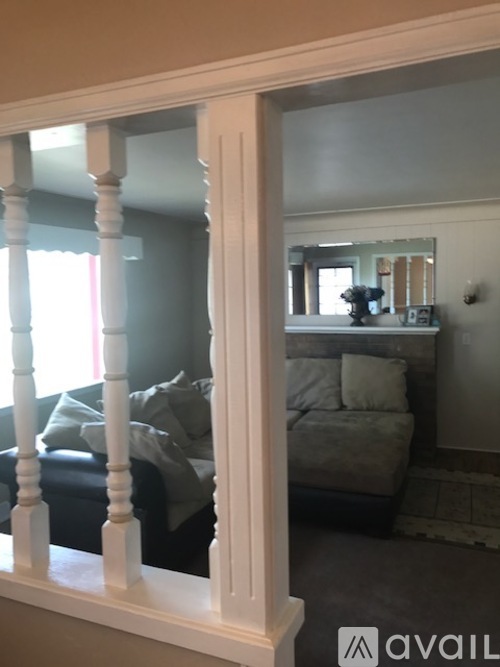 A mirror is on the wall behind a couch.