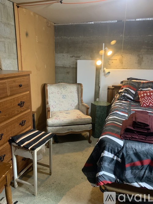 A room with a chair, a bed, and a dresser.
