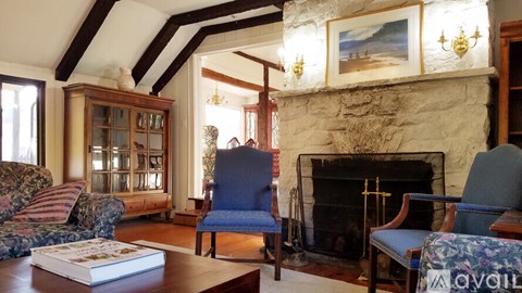 A living room with a fireplace and a painting on the wall.
