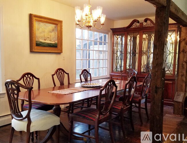 A dining room with a wooden table and chairs.