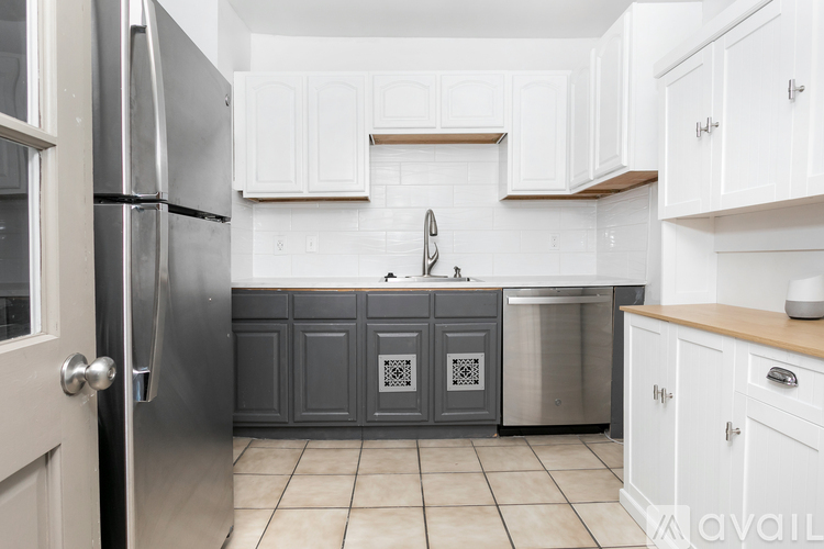 A kitchen with a refrigerator, oven, and cabinets.