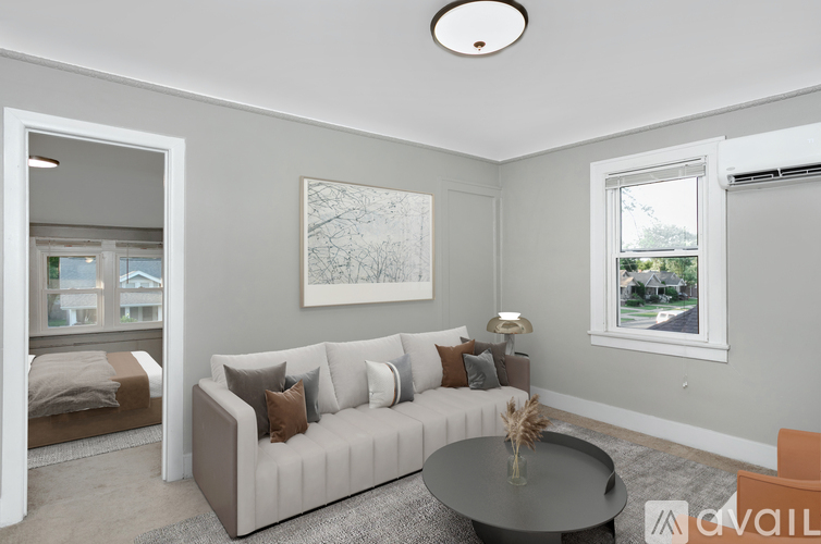 A living room with a grey couch, a coffee table, and a painting on the wall.