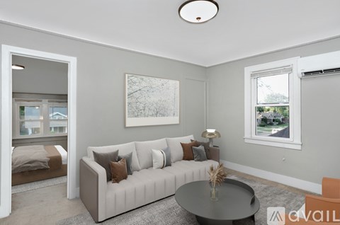 A living room with a grey couch, a coffee table, and a painting on the wall.