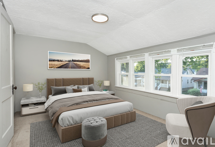 A bedroom with a large bed and a picture of a road on the wall.