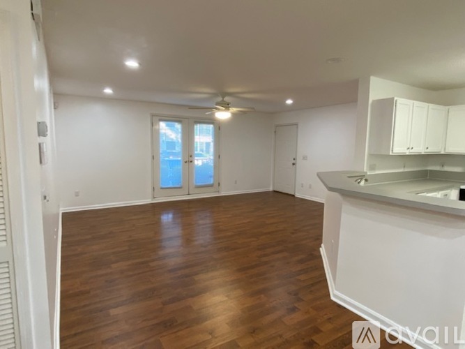A spacious room with wooden floors and white walls.