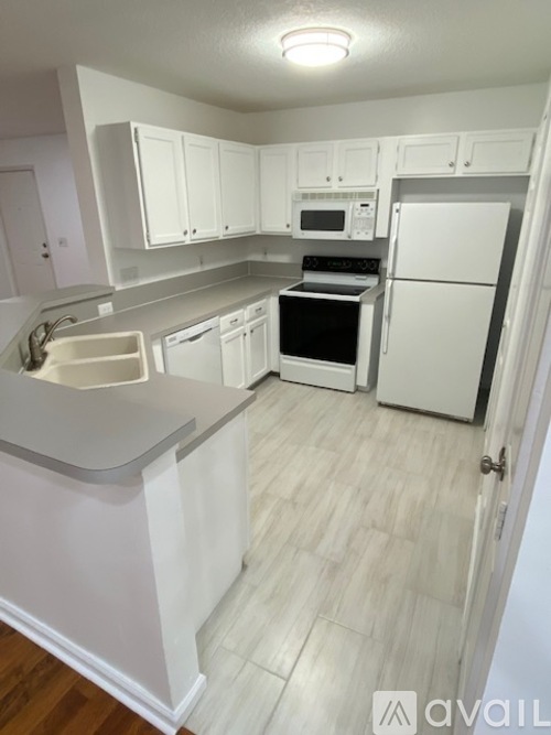A kitchen with white appliances and cabinets.