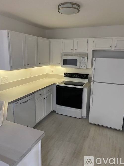 A kitchen with white cabinets and appliances.