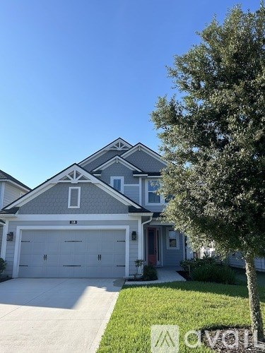 A house with a grey roof and a white garage door.