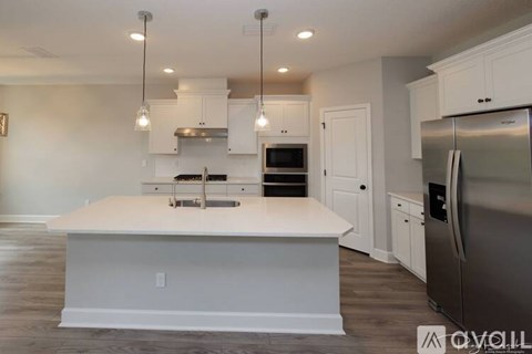 A modern kitchen with a large island and stainless steel appliances.
