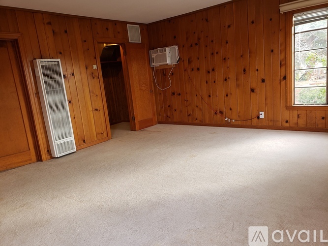 A room with wooden walls and carpeted floor.
