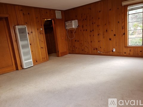 A room with wooden walls and carpeted floor.