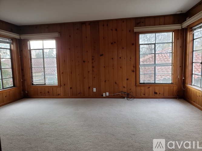 A room with wooden walls and carpeted floor.