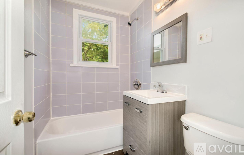 A bathroom with a tub, sink, and window.