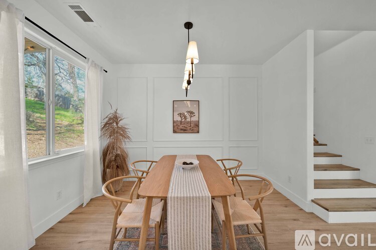 A dining room with a wooden table and chairs.