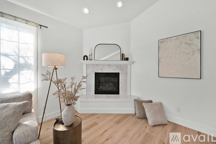 A living room with a fireplace and a painting on the wall.