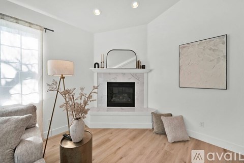 A living room with a fireplace and a painting on the wall.