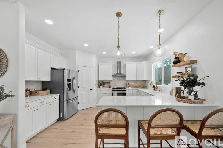 A kitchen with white cabinets and a wooden table.