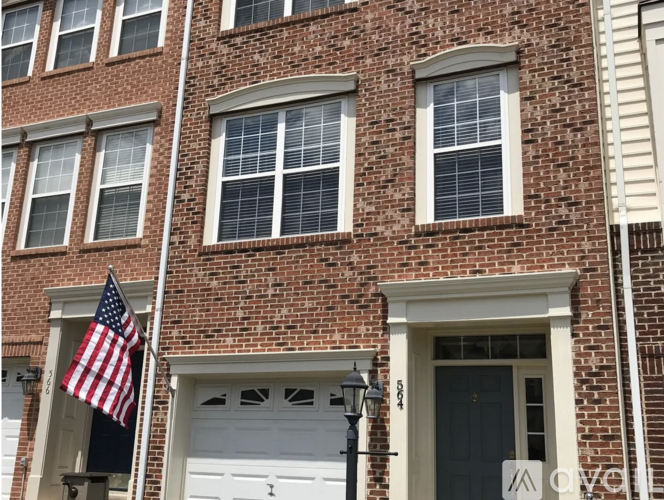 A red brick building with a white garage door and an American flag.