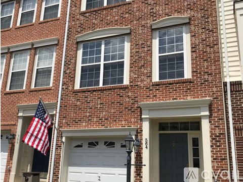 A red brick building with a white garage door and an American flag.