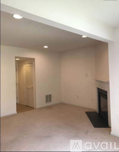 A living room with a fireplace and a door leading to another room.