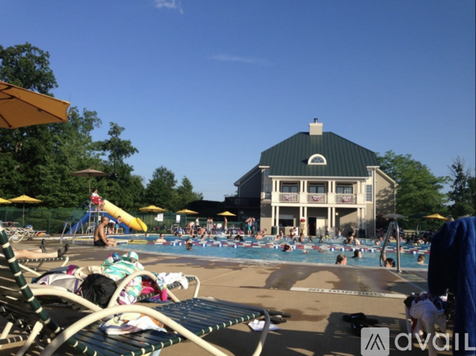 A sunny day at the pool with people swimming and relaxing.