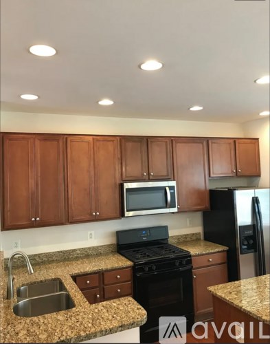 A kitchen with brown cabinets and granite countertops.