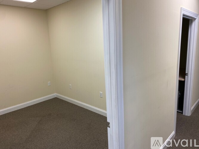A room with a carpeted floor and a doorway leading to another room.