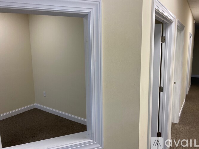 A room with a white door and a carpeted floor.