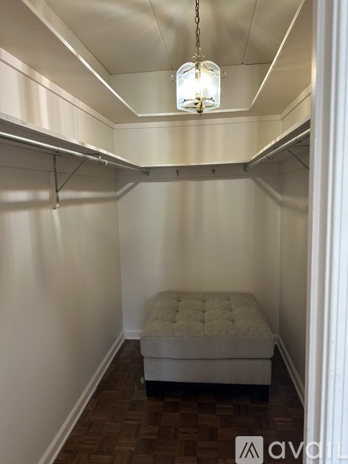 A small bedroom with a bed and a hanging light fixture.