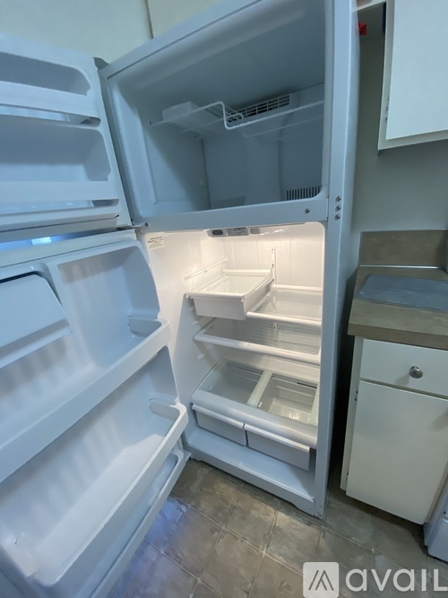 A white refrigerator with its door open is in a kitchen.
