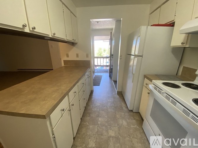 A kitchen with white cabinets and a tiled floor.