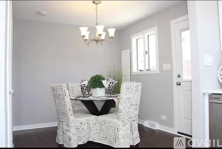 A dining room with a patterned chair and a table with a plant on it.