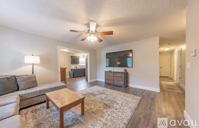 A living room with a couch, a coffee table, and a flat screen TV.