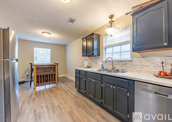 A kitchen with black cabinets and a wooden table.