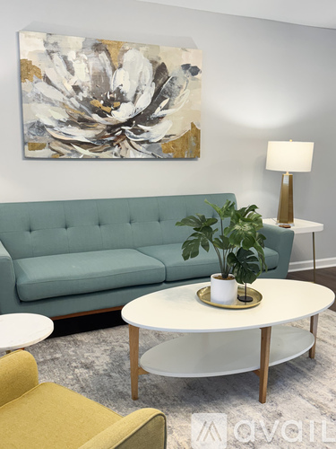 A living room with a green couch, a white coffee table, and a yellow chair.