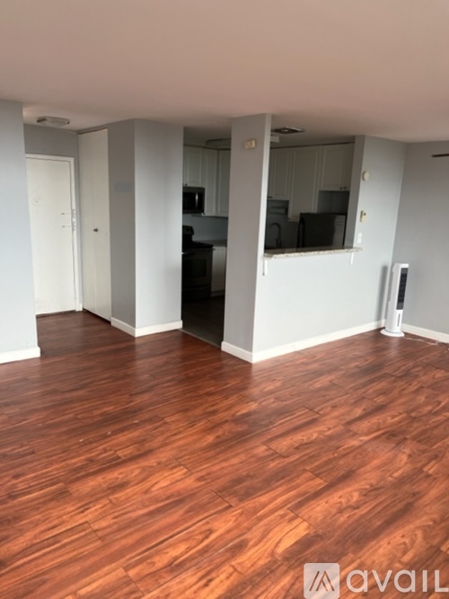 A room with wooden flooring and white walls.