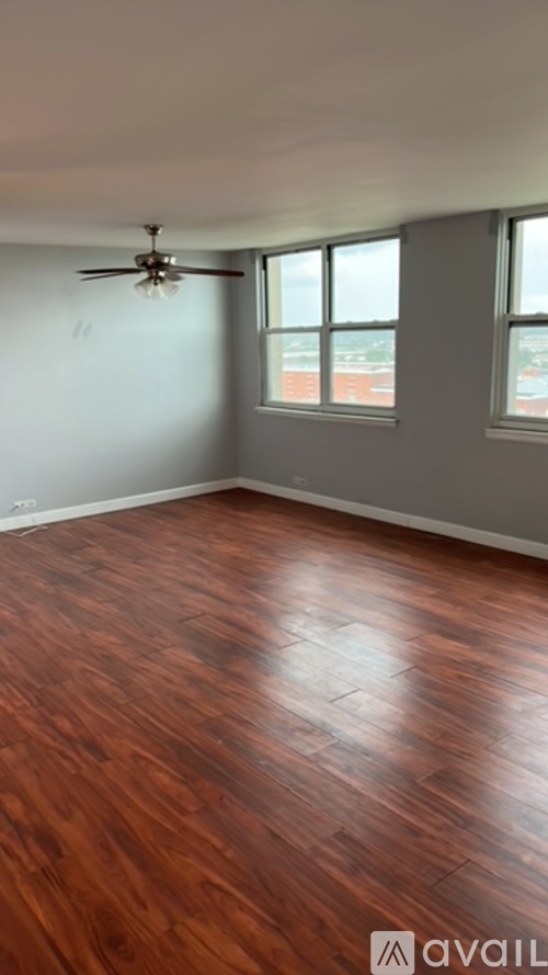 A room with wooden flooring and a ceiling fan.